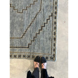 Featuring Cyprus Paphos Hand-Knotted Rug by Jaipur Living at Amethyst Home. The hand-knotted Cyprus collection showcases a modern representation of vintage Kars designs with clean-lined geometric details and fresh colorways. The blue, gray and sage green Paphos design delights with a minimalistic medallion pattern and a similarly styled border. Low pile and na.  Amethyst Home provides interior design, new home construction design consulting, vintage area rugs, and lighting in the Tampa metro area.