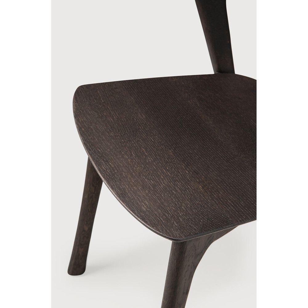Over the years, the Bok dining chair has become one of our most recognisable designs. Designer Alain van Havre combines sculptural elegance and contemporary crafting into a graceful and airy form.
Seating height: 46cm - 18".
Made from brown tainted oak with a varnish finish. Amethyst Home provides interior design, new construction, custom furniture, and area rugs in the Omaha metro area