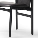 Featuring Baden Sonoma Black Dining Chair by Four Hands at Amethyst Home. Midcentury-inspired with its minimalist wooden frame, this armless dining chair features a low back and float-like seat upholstered in slightly distressed black top-grain leather exclusive to Four Hands. Leather wrap detailing for texture.Overall Dimensions: 19.75"w x 23.25"d x 32.2. Amethyst Home provides interior design, new home construction design consulting, vintage area rugs, and lighting in the Kansas City metro area.