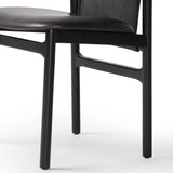 Featuring Baden Sonoma Black Dining Chair by Four Hands at Amethyst Home. Midcentury-inspired with its minimalist wooden frame, this armless dining chair features a low back and float-like seat upholstered in slightly distressed black top-grain leather exclusive to Four Hands. Leather wrap detailing for texture.Overall Dimensions: 19.75"w x 23.25"d x 32.2. Amethyst Home provides interior design, new home construction design consulting, vintage area rugs, and lighting in the Kansas City metro area.