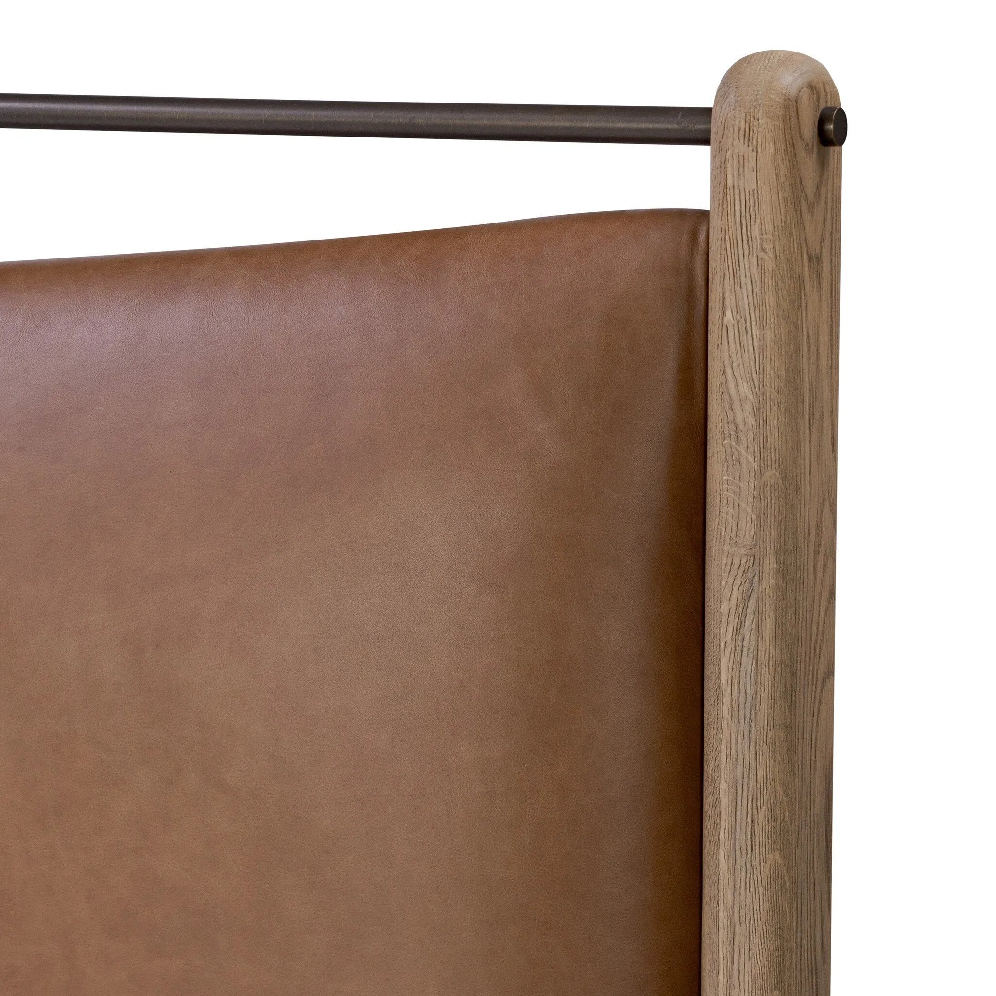 Slightly scooped top-grain leather tufting is bridged with metal bars in brushed brass for modern detailing. Aged smoked oak