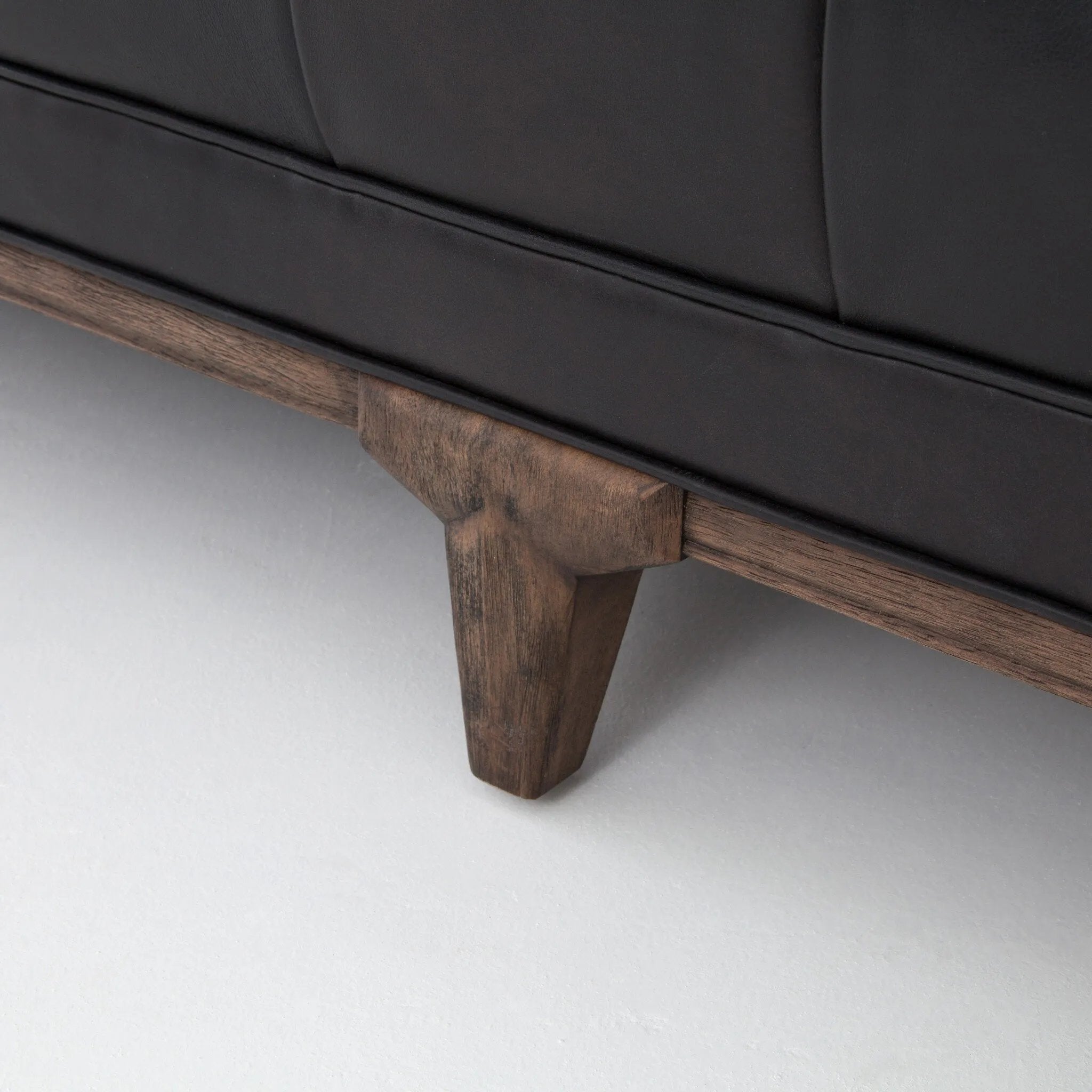 A modernized midcentury silhouette meets the traditional Chesterfield sofa, all in a compact profile perfect for smaller spaces. Top-grain leather in a classic black, button tufting and a smooth touch bring deep comfort to lounging Amethyst Home provides interior design, new home construction design consulting, vintage area rugs, and lighting in the Scottsdale metro area.