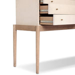 A soft statement console table with ample storage, inspired by a dresser silhouette. The elevated case is wrapped in painted linen and sits atop an oak base for a light and airy look Amethyst Home provides interior design, new home construction design consulting, vintage area rugs, and lighting in the Alpharetta metro area.