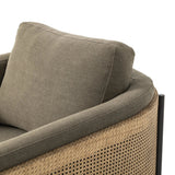 On-trend and expertly tailored, a texture-driven chair is upholstered in an olive flax/linen blend and wrapped with natural rattan, with linear iron legs finished in a complementary gunmetal Amethyst Home provides interior design, new home construction design consulting, vintage area rugs, and lighting in the Nashville metro area.