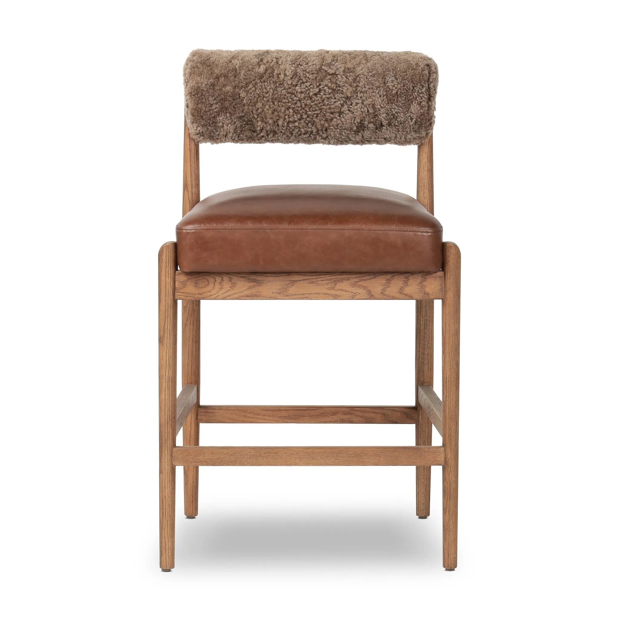 Featuring Jazelle Taupe Shearling Counter Stool by Four Hands at Amethyst Home. Bring mixed materials to the counter. Solid oak, top-grain leather and soft shearling fuse for a playful update to midcentury and Seventies styling. Overall Dimensions: 22.25"w x 25.75"d x 36.50"h. Amethyst Home provides interior design, new home construction design consulting, vintage area rugs, and lighting in the Boston metro area.