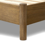 Rounded, chunky dowel legs in an amber oak finish frame the tan top-grain leather headboard of this simple-but-striking bed frame Amethyst Home provides interior design, new home construction design consulting, vintage area rugs, and lighting in the Kansas City metro area.