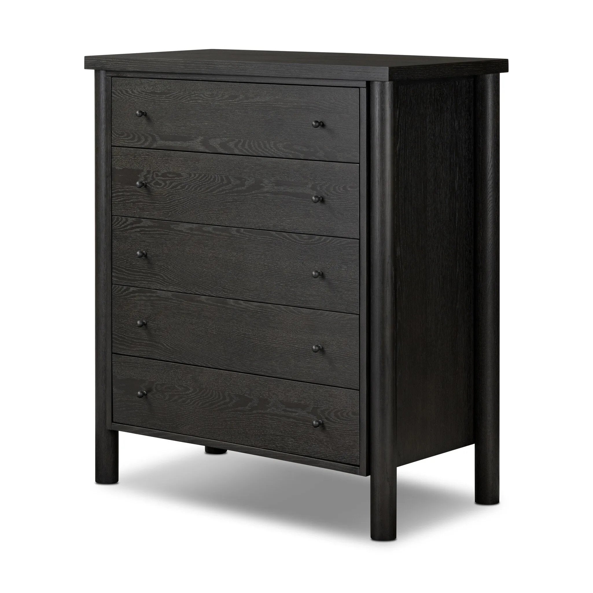Create storage space in the bedroom with a five-drawer dresser of ebony-finished oak. Chunky dowel legs support a tall silhouette and overhang top, all finished out with simple gunmetal hardware Amethyst Home provides interior design, new home construction design consulting, vintage area rugs, and lighting in the Charlotte metro area.
