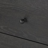 Create storage space in the bedroom with a five-drawer dresser of ebony-finished oak. Chunky dowel legs support a tall silhouette and overhang top, all finished out with simple gunmetal hardware Amethyst Home provides interior design, new home construction design consulting, vintage area rugs, and lighting in the Los Angeles metro area.