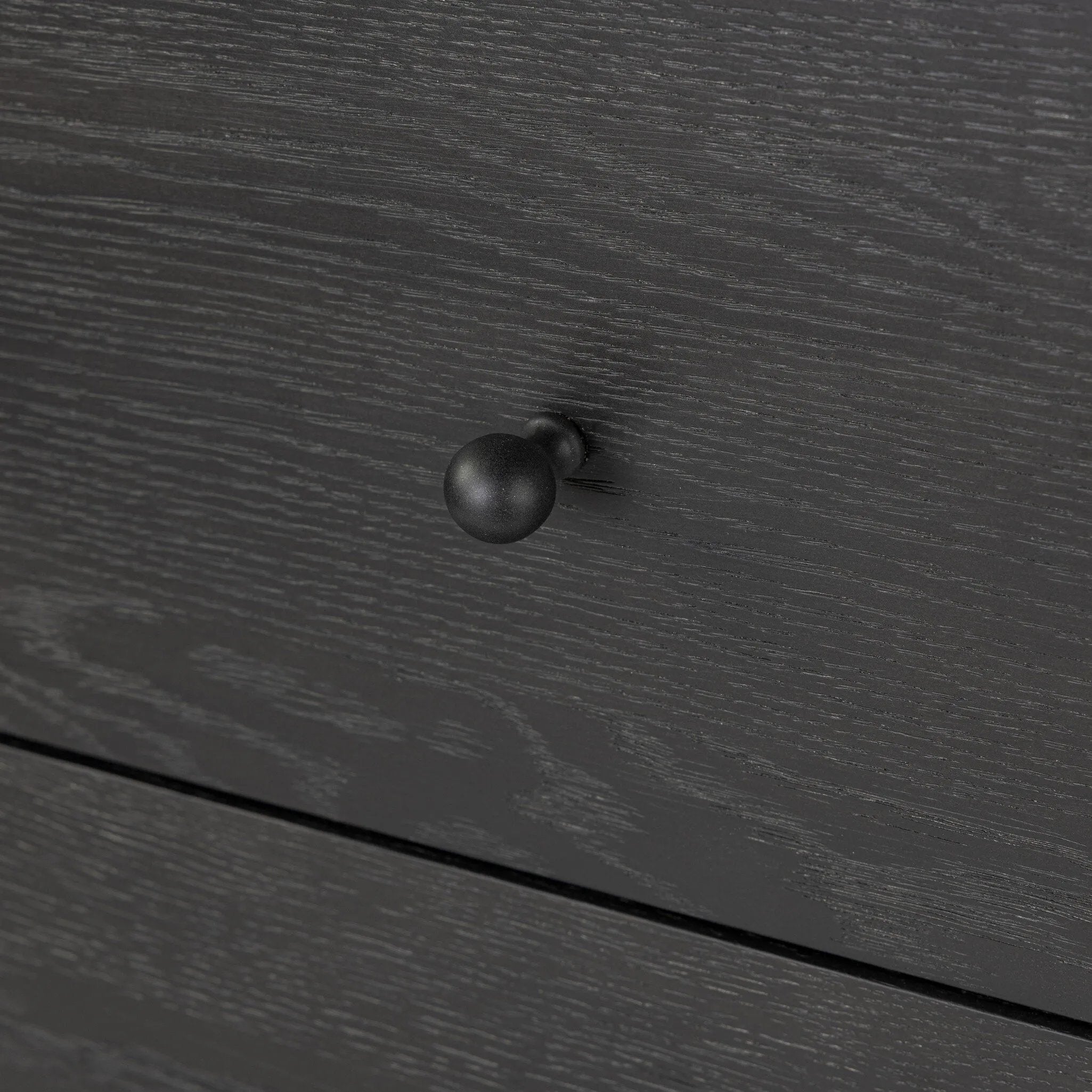 Create storage space in the bedroom with a five-drawer dresser of ebony-finished oak. Chunky dowel legs support a tall silhouette and overhang top, all finished out with simple gunmetal hardware Amethyst Home provides interior design, new home construction design consulting, vintage area rugs, and lighting in the Los Angeles metro area.