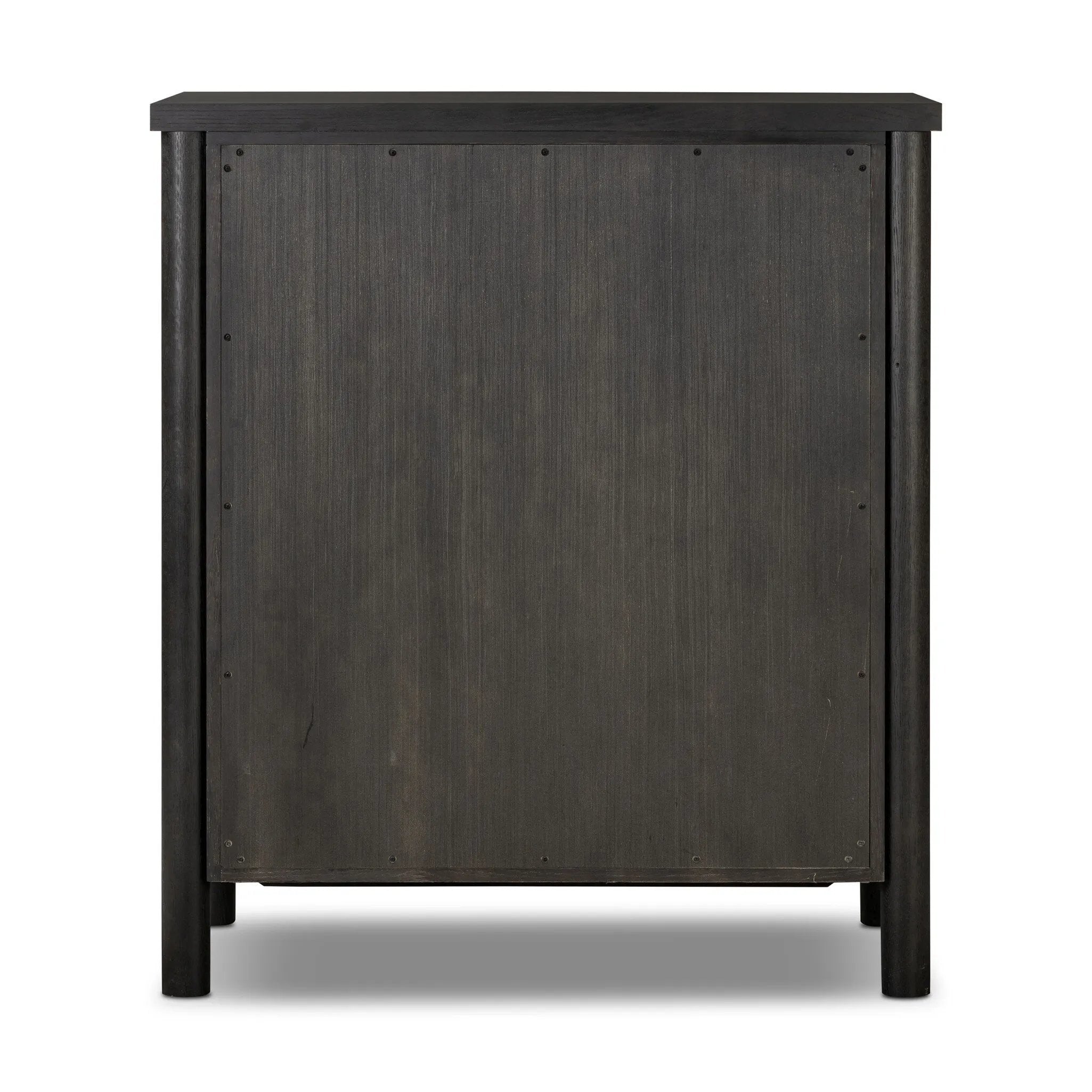 Create storage space in the bedroom with a five-drawer dresser of ebony-finished oak. Chunky dowel legs support a tall silhouette and overhang top, all finished out with simple gunmetal hardware Amethyst Home provides interior design, new home construction design consulting, vintage area rugs, and lighting in the Miami metro area.