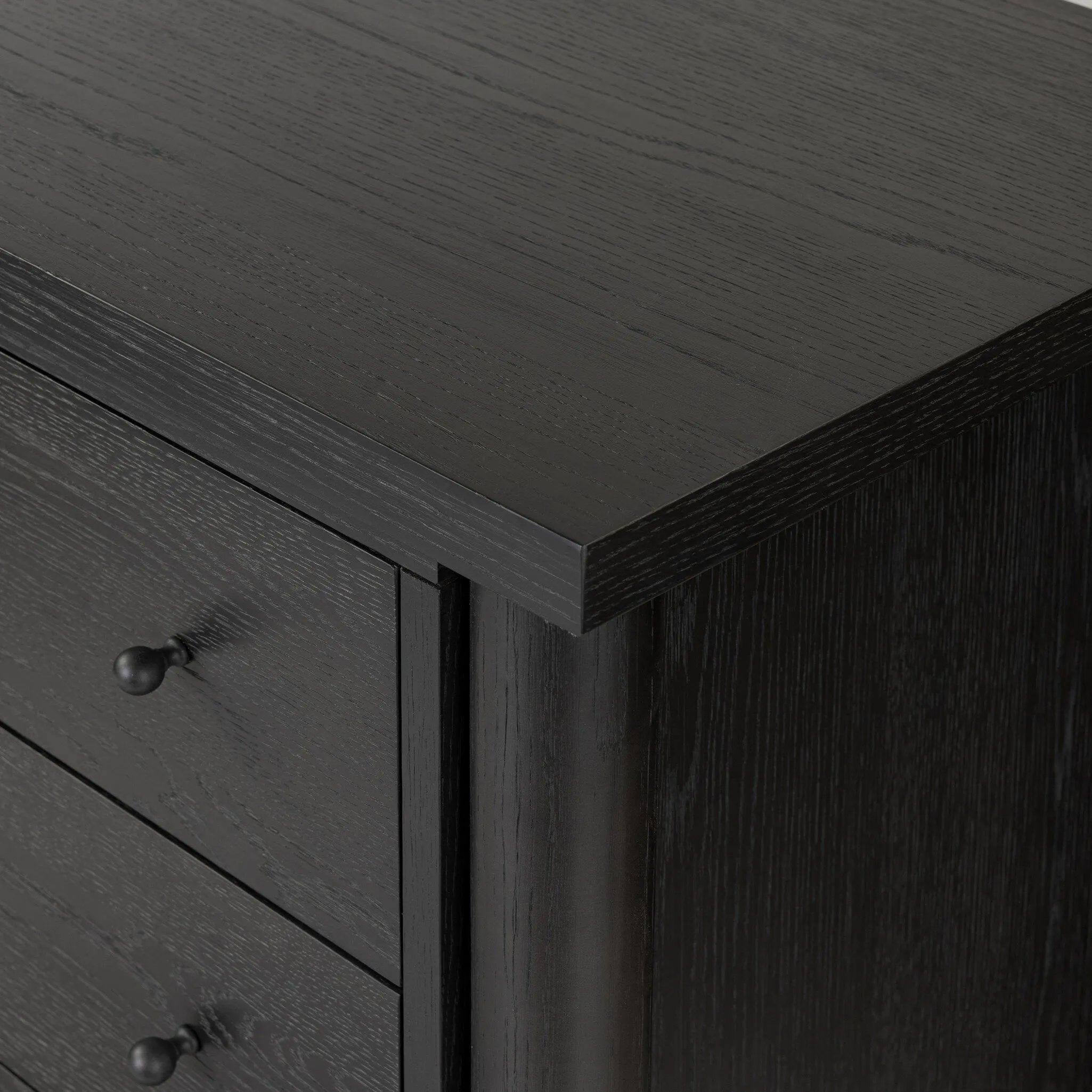 Create storage space in the bedroom with a five-drawer dresser of ebony-finished oak. Chunky dowel legs support a tall silhouette and overhang top, all finished out with simple gunmetal hardware Amethyst Home provides interior design, new home construction design consulting, vintage area rugs, and lighting in the Tampa metro area.