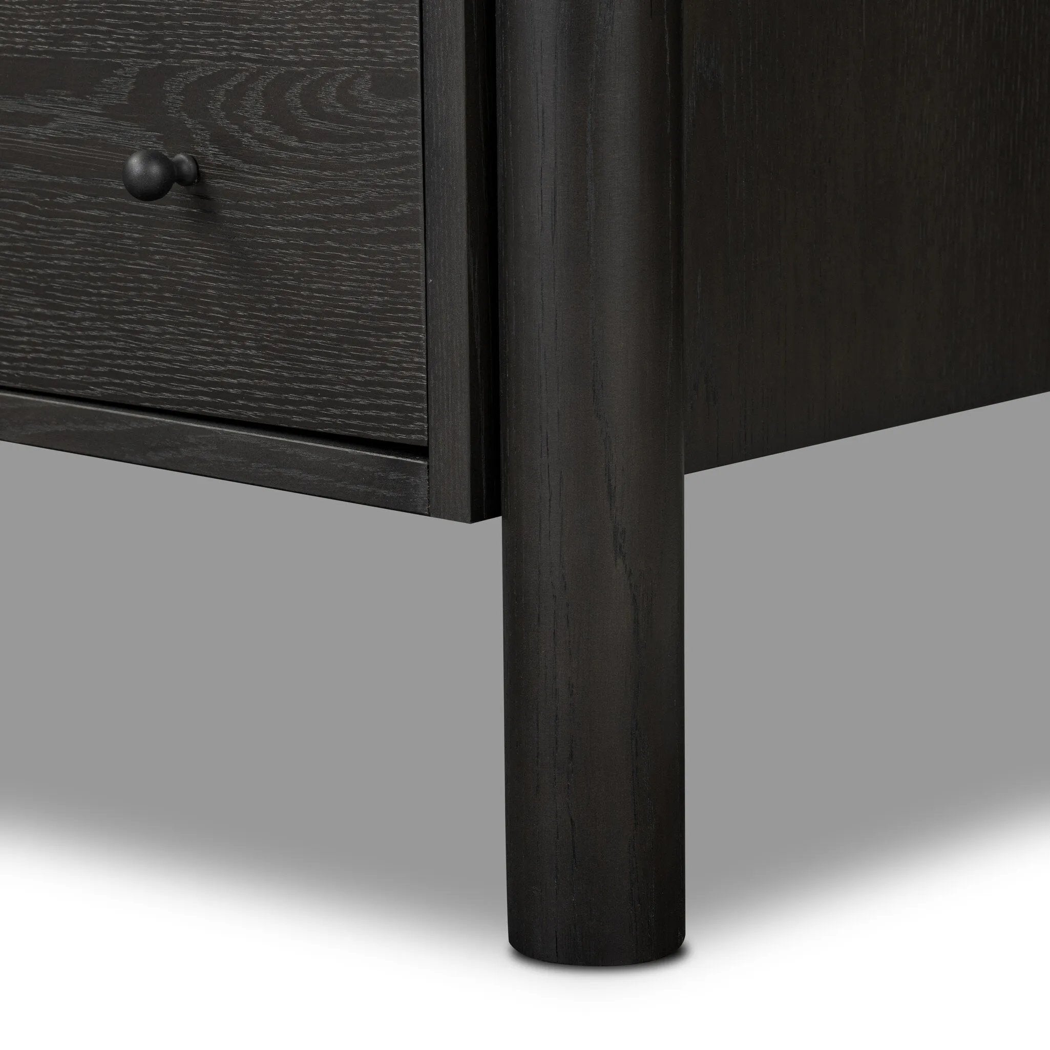 Create storage space in the bedroom with a five-drawer dresser of ebony-finished oak. Chunky dowel legs support a tall silhouette and overhang top, all finished out with simple gunmetal hardware Amethyst Home provides interior design, new home construction design consulting, vintage area rugs, and lighting in the Winter Garden metro area.
