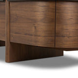 Dark brown walnut is aesthetically shaped with fluid, rounded corners on a ski leg base. The seamless design features six spacious drawers with metal bar hardware that runs along the tops of the drawers Amethyst Home provides interior design, new home construction design consulting, vintage area rugs, and lighting in the Nashville metro area.