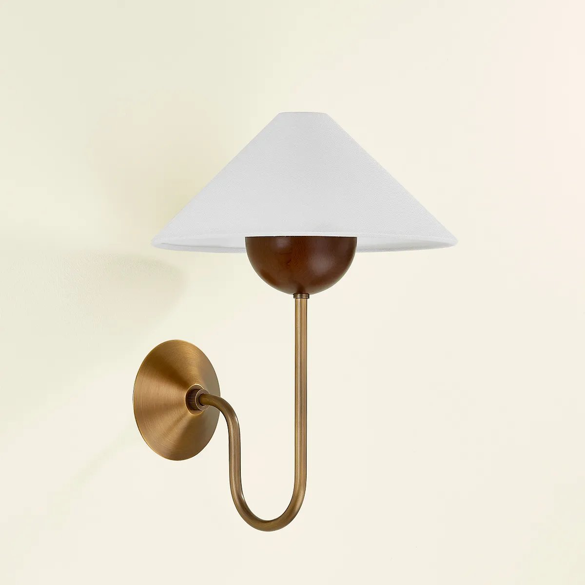 Combining geometric shapes and three distinctive earthy materials, the Evan sconce generates its own visual design language. The design-forward composition includes a swooping J-arm in Patina Brass, leading into an overscale walnut wood bobeche. As a note of contrast, the fixture is topped by a sharply tapered shade made from grained white linen. Amethyst Home provides interior design, new home construction design consulting, vintage area rugs, and lighting in the Newport Beach metro area.