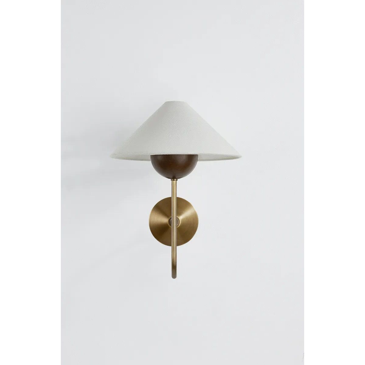 Combining geometric shapes and three distinctive earthy materials, the Evan sconce generates its own visual design language. The design-forward composition includes a swooping J-arm in Patina Brass, leading into an overscale walnut wood bobeche. As a note of contrast, the fixture is topped by a sharply tapered shade made from grained white linen. Amethyst Home provides interior design, new home construction design consulting, vintage area rugs, and lighting in the Salt Lake City metro area.