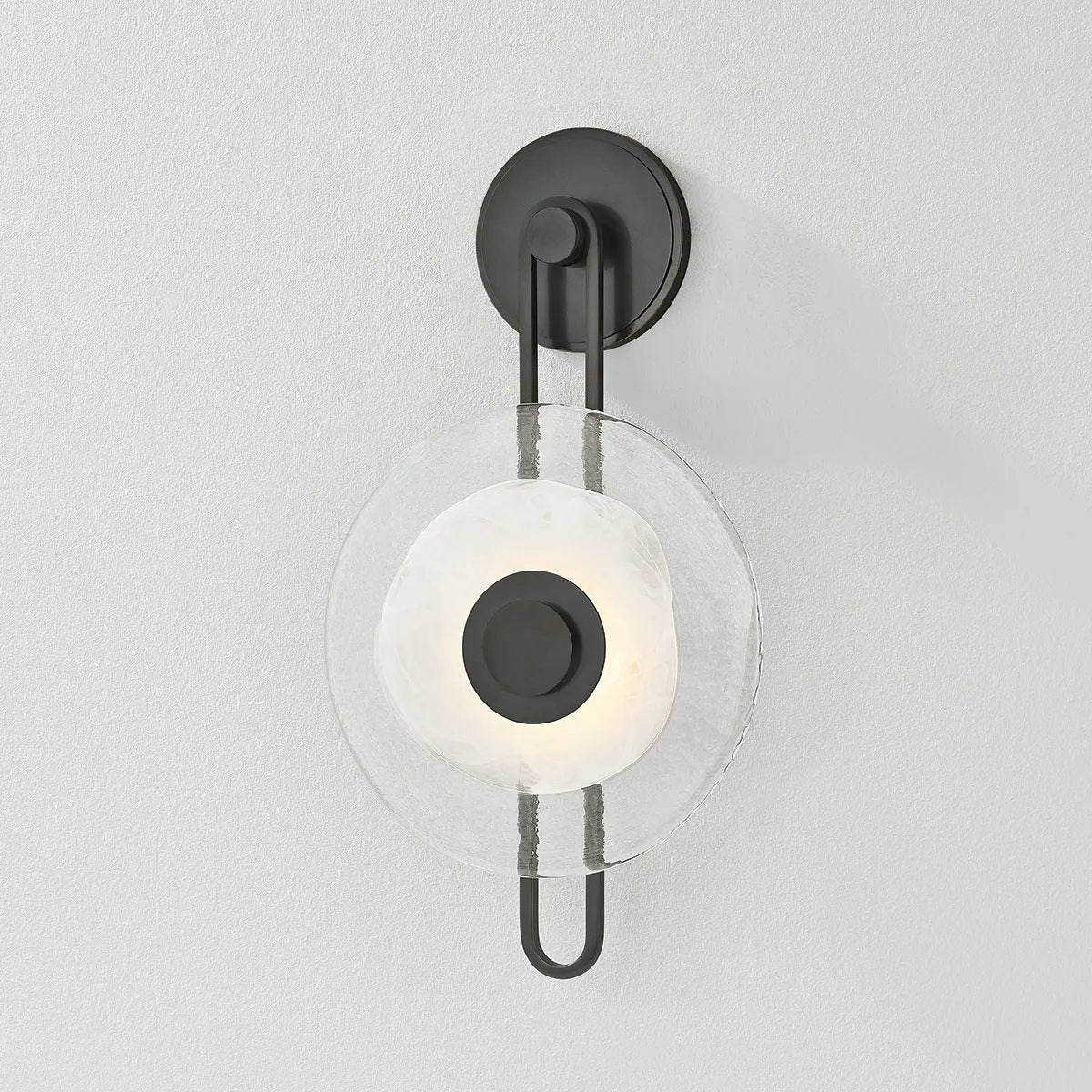 The earring-like design of Keuka Park exudes ornamental, graphic appeal. A thick disc of Blonchino Piastre glass is illuminated at the point where it attaches to the racetrack frame of this striking wall fixture. Whether finished in Aged Brass or Old Bronze, Keuka Park brings modernist artistry to any wall. Amethyst Home provides interior design, new home construction design consulting, vintage area rugs, and lighting in the Calabasas metro area.