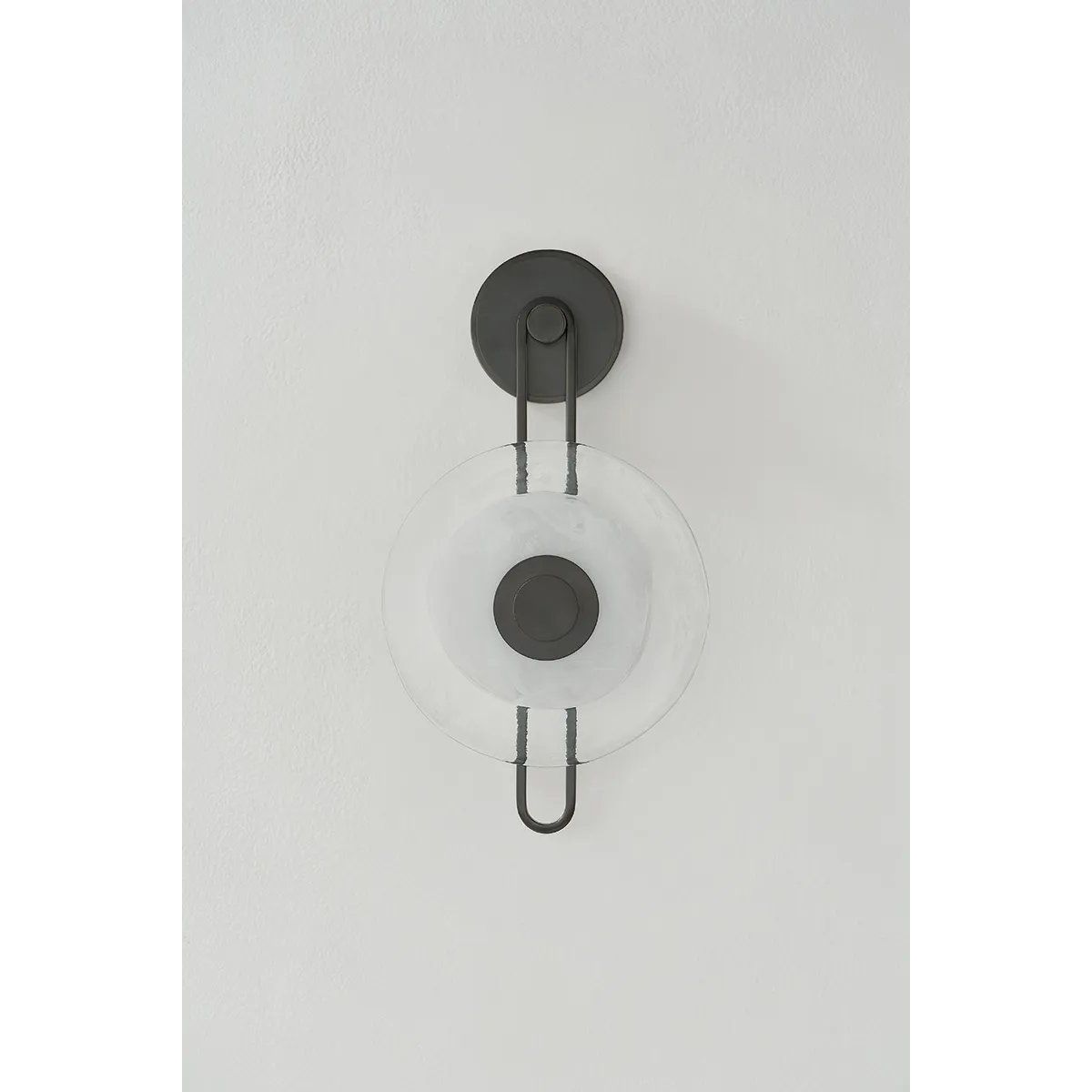 The earring-like design of Keuka Park exudes ornamental, graphic appeal. A thick disc of Blonchino Piastre glass is illuminated at the point where it attaches to the racetrack frame of this striking wall fixture. Whether finished in Aged Brass or Old Bronze, Keuka Park brings modernist artistry to any wall. Amethyst Home provides interior design, new home construction design consulting, vintage area rugs, and lighting in the Miami metro area.