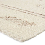 Featuring Leona  Essek Rug by Jaipur Living at Amethyst Home. The texture-rich Leona Essek offers an assortment of updated kilim looks, re-invented with the on-trend shearling style and neutral, modern palettes. The handwoven Essek rug features a globally inspired, light brown, stripe and tribal pattern on a neutral cream base. This 100% wool accent piece d. Amethyst Home provides interior design, new home construction design consulting, vintage area rugs, and lighting in the Charlotte metro area.