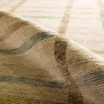 Featuring Raza Hand-Knotted Rug by Jaipur Living at Amethyst Home. The Raza design reinvents the timeless plaid pattern, fusing classic charm with a modern edge. Soft beige tones, punctuated by a blue accent, elevate any mid-century modern space. Handcrafted from naturally stain-resistant wool, this rug handles medium-traffic areas, kids, and pets with eas. Amethyst Home provides interior design, new home construction design consulting, vintage area rugs, and lighting in the Alpharetta metro area.