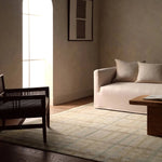 Featuring Raza Hand-Knotted Rug by Jaipur Living at Amethyst Home. The Raza design reinvents the timeless plaid pattern, fusing classic charm with a modern edge. Soft beige tones, punctuated by a blue accent, elevate any mid-century modern space. Handcrafted from naturally stain-resistant wool, this rug handles medium-traffic areas, kids, and pets with ease. Amethyst Home provides interior design, new home construction design consulting, vintage area rugs, and lighting in the Charlotte metro area.