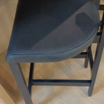 This dark, monochromatic look inspired by Greek design meets black-finished Rosa Morada with black top-grain leather. A slim T-shape frame is perfectly sized for the counter.Overall Dimensions: 20.25"w x 17.75"d x 36.50"hWeight : 11.90 lbsMaterials : Top Grain Leather, Solid Rosa Morada, 100% Polyurethane Foam Amethyst Home provides interior design, new home construction design consulting, vintage area rugs, and lighting in the Kansas City metro area.