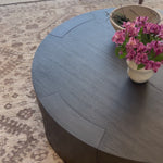 Made from thick, charcoal-finished oak, a rounded coffee table features four legs that pull through to the top, for an intriguing design detail.Overall Dimensions: 48.00"w x 48.00"d x 13.00"hWeight : 94.80 lbsMaterials : Oak Veneer Amethyst Home provides interior design, new home construction design consulting, vintage area rugs, and lighting in the Winter Garden metro area.