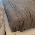 Low profile luxury with an extra-wide fully upholstered headboard that brings drama to the bedroom. Modern Italian styling is both substantial and plush with clean lines all around. Fully upholstered in a textural cotton/linen blend with extra cushioning on the footboard and side rails. This bed is not compatible with an adjustable mattress. Amethyst Home provides interior design, new home construction design consulting, vintage area rugs, and lighting in the Calabasas metro area.