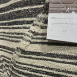 Iman Ivory/Charcoal Rug - Amethyst Home A new take on Moroccan style rugs, the Iman Collection is hand-knotted of 100% wool pile by skilled artisans in India. The surface features linear and braided details, creating tonal variations that make each piece unique. Plus, each design is finished with playful fringe.