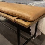 Airy, black-finished iron legs support a nettlewood dining bench of a chic, comfy layer of brandy top-grain leather on this Gabine Accent Bench - Brandy. A handsome piece to add to any bedroom, living room, or entryway.   Overall Dimensions: 72.00"w x 18.00"d x 22.00"h