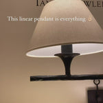 The Cesta Linear Chandelier by Visual Comfort is finished in aged iron with a linen shade. We love the timeless look it brings to a living room, dining room, or other large area.   Designer: Ian K. Fowler