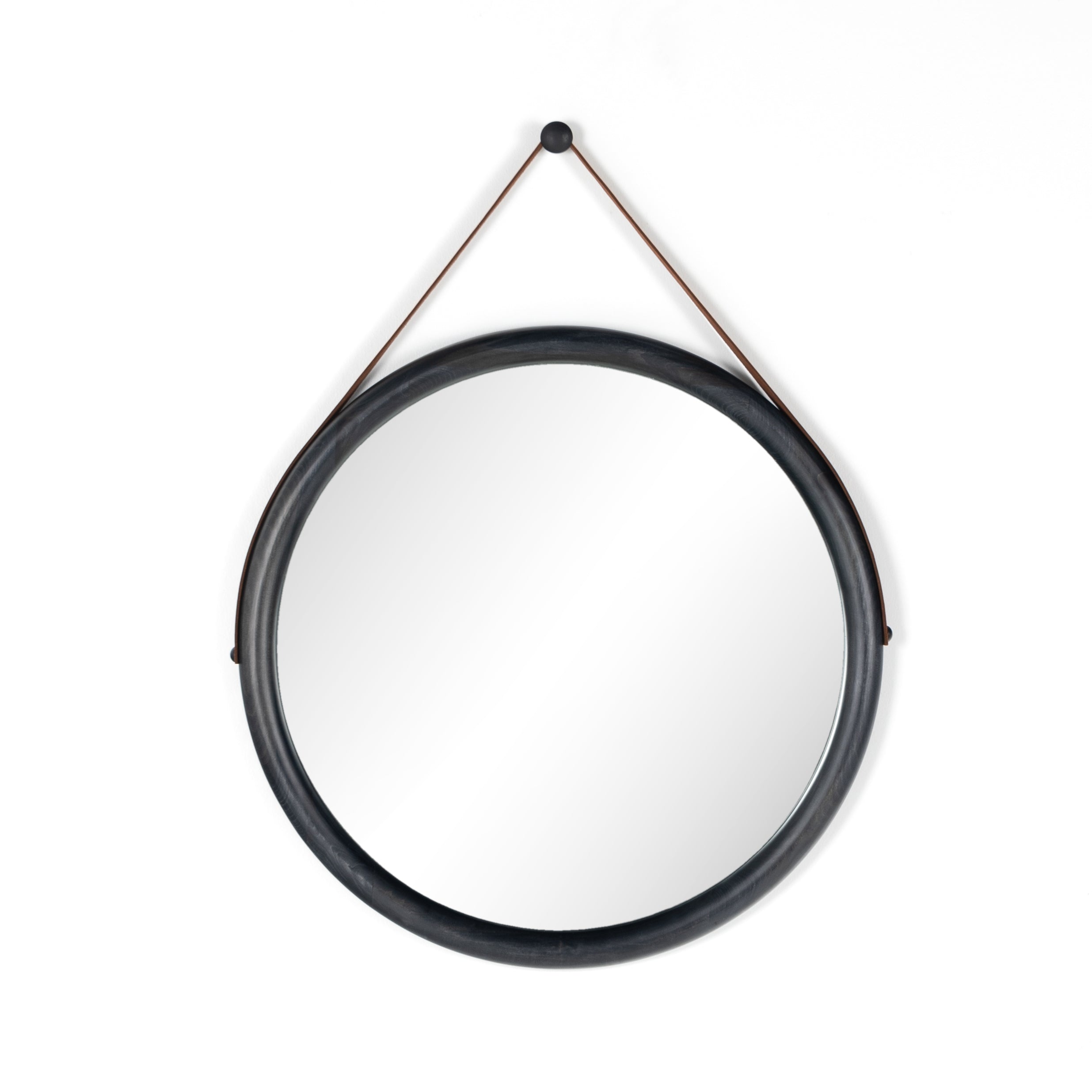 Featuring Des Mirror by Four Hands at Amethyst Home. The Des Mirror is hung by a handsome, toffee-colored top grain leather strap. We love the fresh take on what would otherwise be a traditional, round mirror. The mirror is framed in black-washed popular and would like amazing hung in an entryway, bedroom, or other space. 
Overall Dimensions: 30"W x 1.50.  Amethyst Home provides interior design, new home construction design consulting, vintage area rugs, and lighting in the Kansas City metro area.