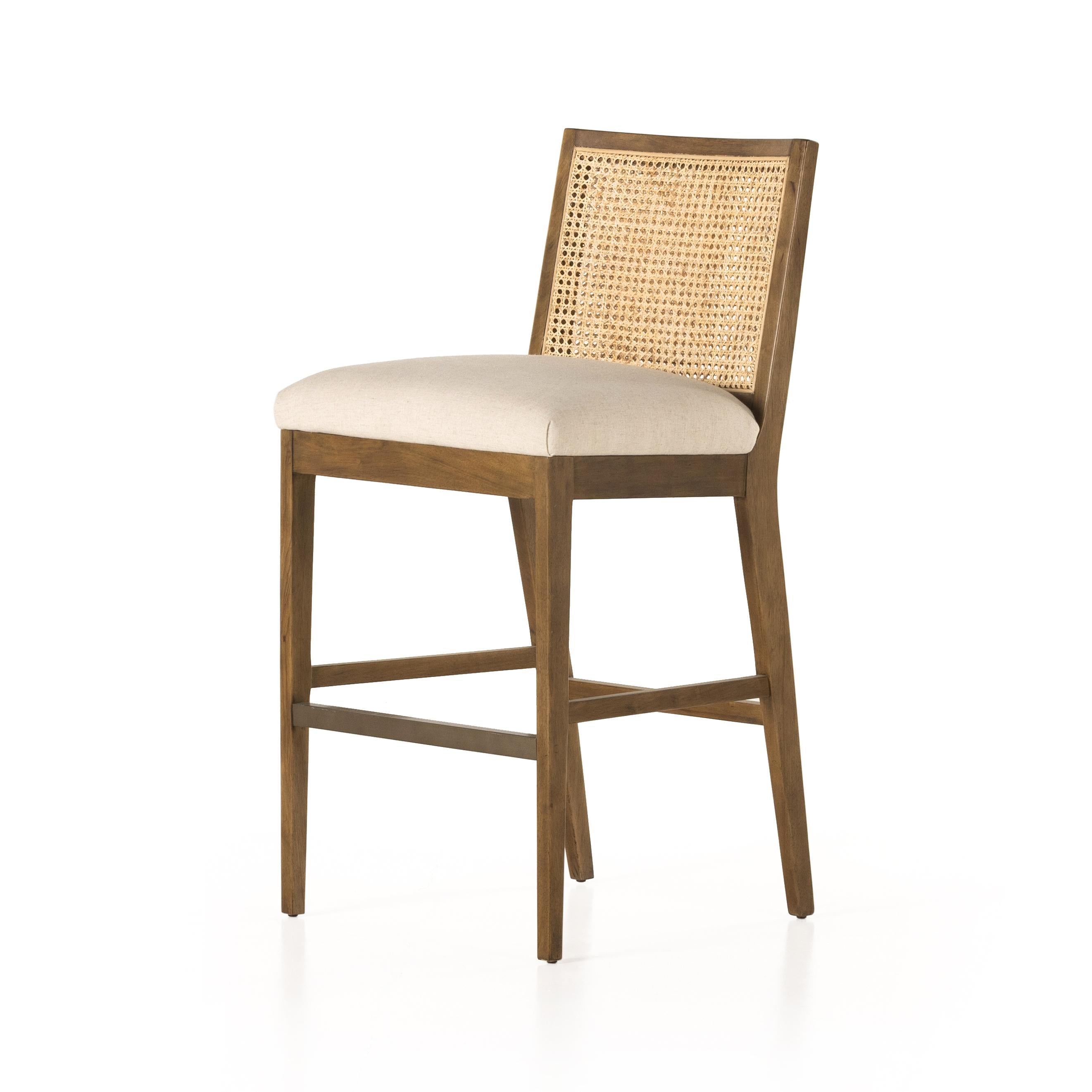 Featuring Antonia Solid Parawood Cane Armless Stool by Four Hands at Amethyst Home. Mixed materials refresh retro stool seating. Light-toasted nettlewood frames a textural inlay of natural cane for a clean, monochromatic look, with a light, linen-blend seat of high-performance fabric brings smart sensibility to bar-style seating. Performance fabrics are sp. Amethyst Home provides interior design, new home construction design consulting, vintage area rugs, and lighting in the Alpharetta metro area.