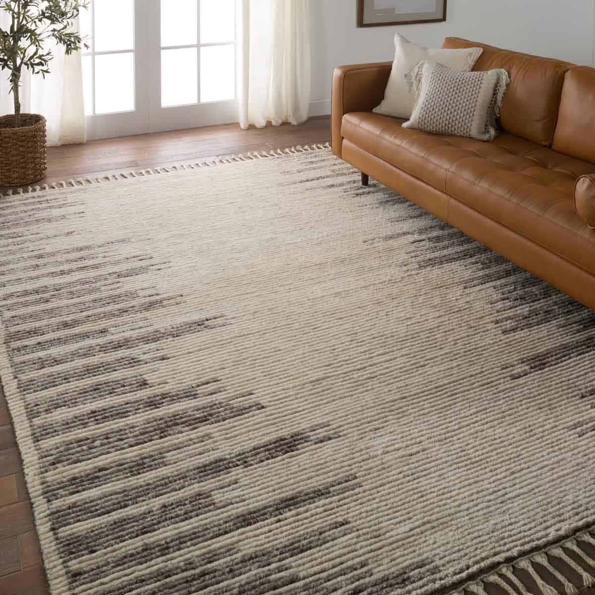 Featuring Alpine Patra Hand-Knotted Rug by Jaipur Living at Amethyst Home. Inspired by textiles from the Tullu region in Morocco, the Patra area rug showcases a linear design in neutral shades of cream, taupe, brown, and gray. This high-piled accent lends warmth and comfort to any space with durable wool hand-knotted onto a cotton foundation. Braided fring. Amethyst Home provides interior design, new home construction design consulting, vintage area rugs, and lighting in the Des Moines metro area.