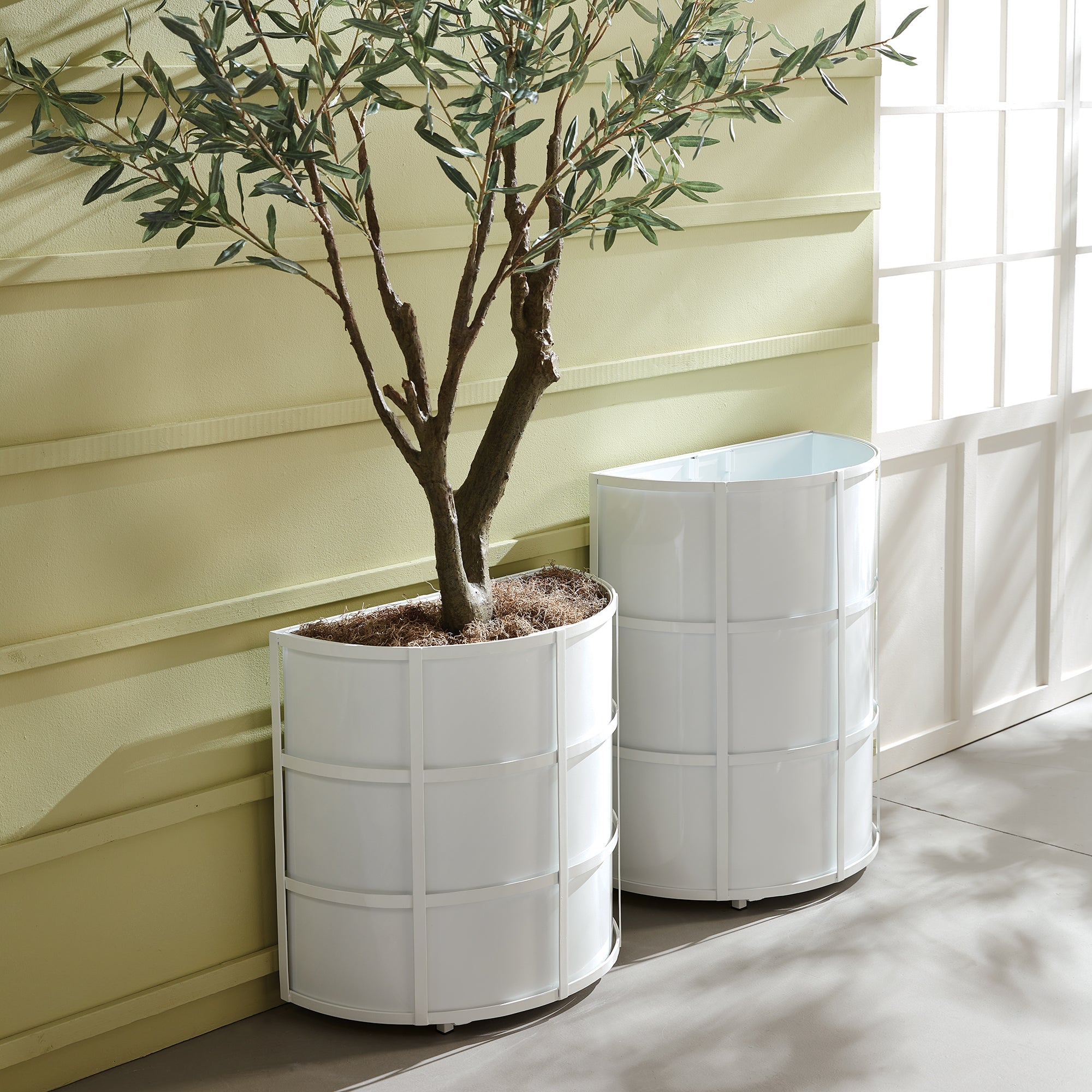 Raised off the ground for proper drainage, this well-scaled demilune planter is the modern interpretation of an antique planter. It is fully powder-coated, and has a removable liner with recessed handles. A statement piece for between windows, garage doors and on patio. Amethyst Home provides interior design, new construction, custom furniture, and area rugs in the Laguna Beach metro area.