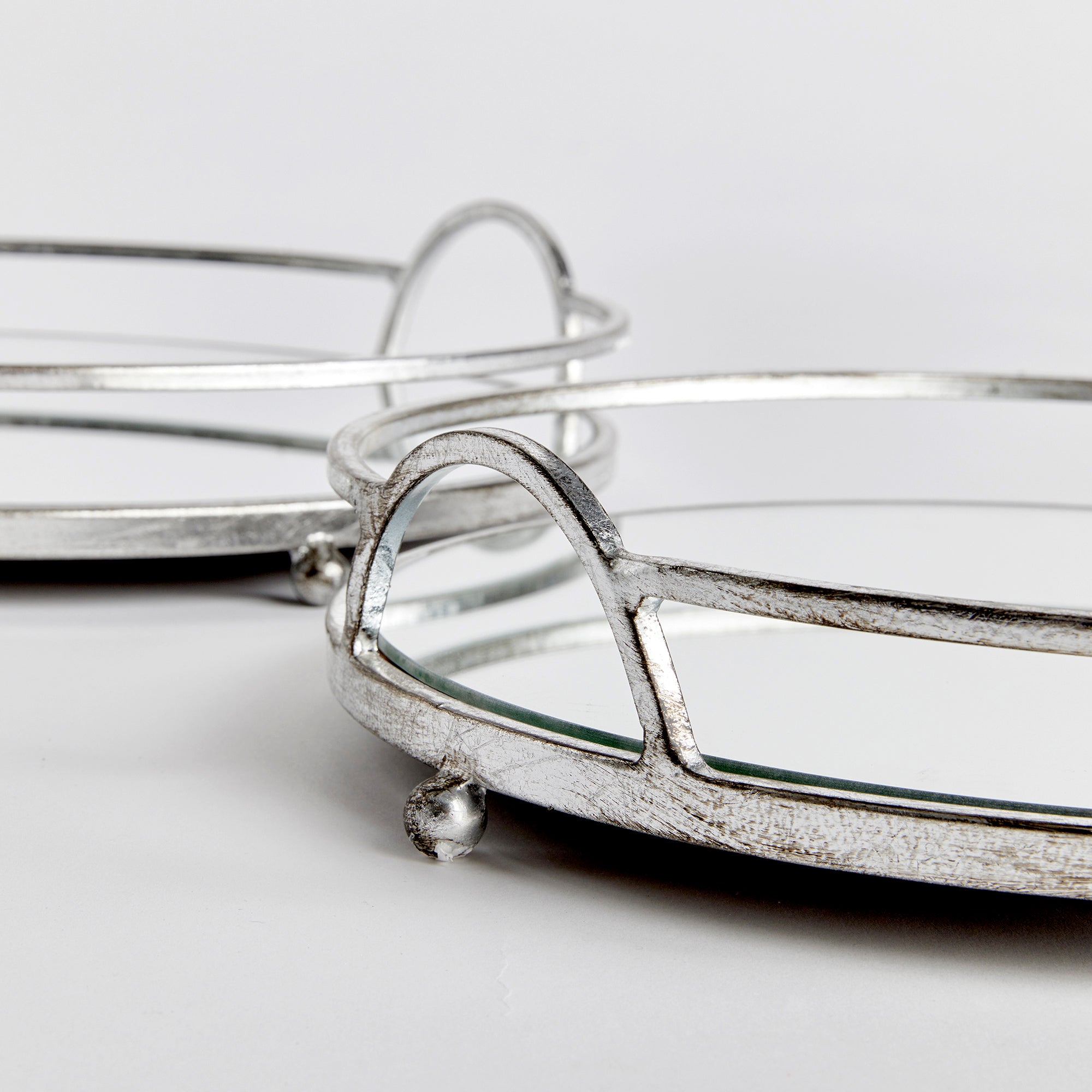 These round mirrored trays are an unexpected combination of antique silver and glass. A classic look with a modern twist. Amethyst Home provides interior design, new construction, custom furniture, and area rugs in the Seattle metro area.