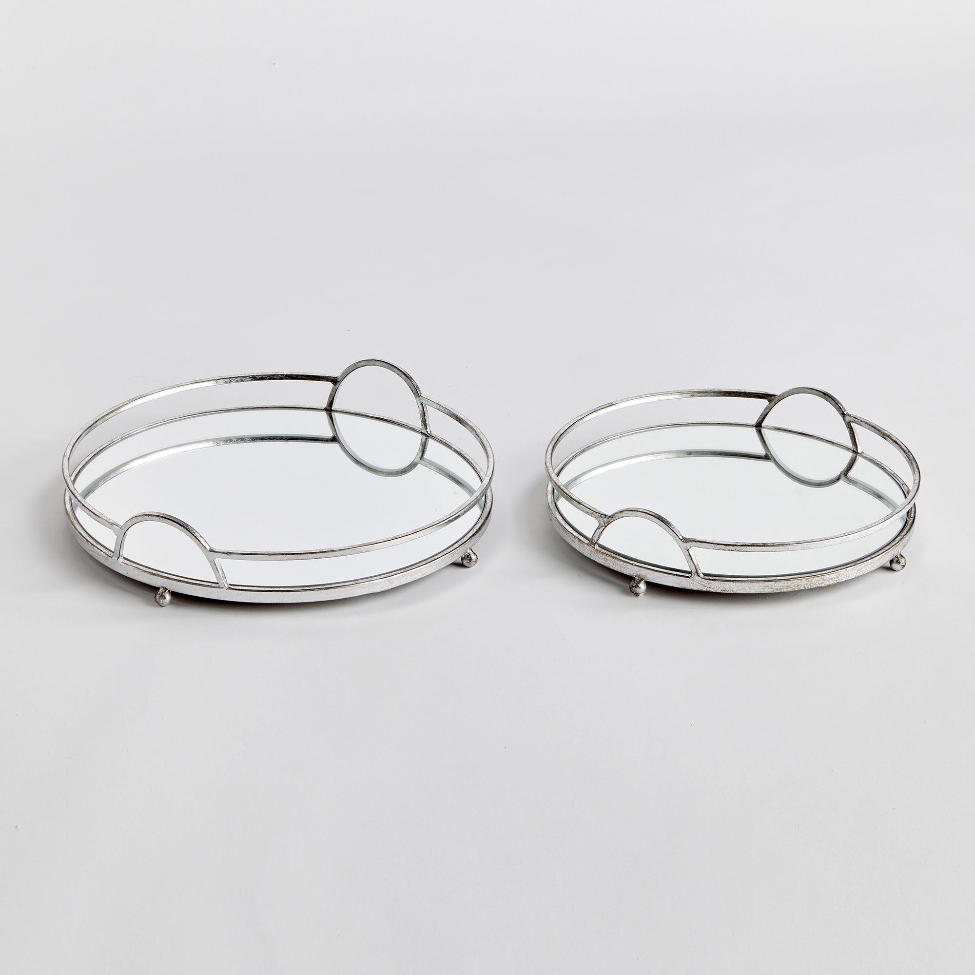 These round mirrored trays are an unexpected combination of antique silver and glass. A classic look with a modern twist. Amethyst Home provides interior design, new construction, custom furniture, and area rugs in the Tampa metro area.