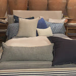 Cisco Brothers April Bed is designed and constructed in Los Angeles. The pinched edges and clean lines bring a modern, minimalist feel to any bedroom. Photographed in White Denim and Bengal Pin Striped Indigo. Amethyst Home provides interior design, new home construction design consulting, vintage area rugs, and lighting in the Alpharetta metro area.