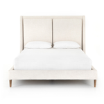 Welcome light, livable luxury into your bedroom with a fully upholstered bed. A tapered headboard features a fixed oversized cushion of high-performance fabric, creating a soft, layered look. Understated wooden legs complete the design. Amethyst Home provides interior design, new home construction design consulting, vintage area rugs, and lighting in the Los Angeles metro area.