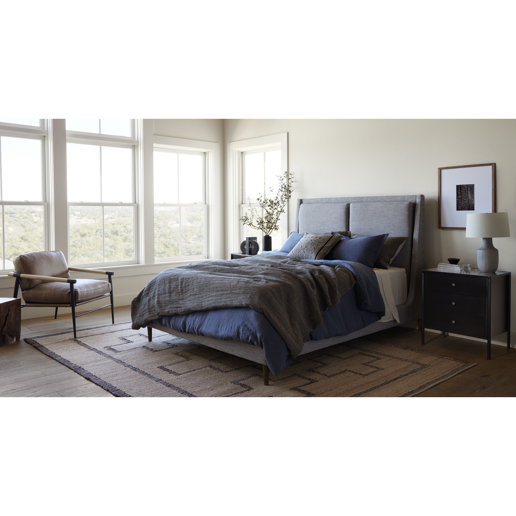 Featuring Potter Manor Grey Bed by Four Hands at Amethyst Home. Light, livable luxury. Upholstered in a grey synthetic-blend, a tapered headboard features fixed overscale pillows, for a calming look with great depth. Wire-brushed parawood legs lend a warm, natural finishing touch. Performance fabrics are specially created to withstand spills, stains, high traff. Amethyst Home provides interior design, new home construction design consulting, vintage area rugs, and lighting in the Omaha metro area.