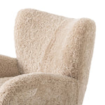 Relax into the curved arms and subtle wing back shape of this classic reading chair. Upholstered in an ethically sourced, natural beige shearling for extra comfort and texture. Crafted with S-spring suspension, a loose cushion and hidden legs beneath Amethyst Home provides interior design, new home construction design consulting, vintage area rugs, and lighting in the Tampa metro area.