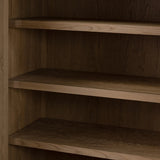 Crafted from sandy solid oak in a waterfall silhouette, this armoire adds a touch of contemporary simplicity to your bedroom. Double doors open to spacious shelving, complemented by a bottom drawer for extra storage. The piece’s bullnose edge and oval iron hardware add variety. Amethyst Home provides interior design, new home construction design consulting, vintage area rugs, and lighting in the Houston metro area.