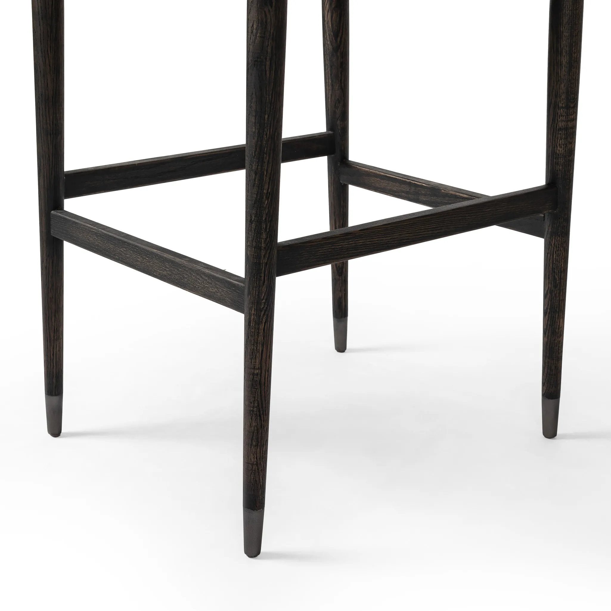 Featuring Anton Savile Flax Bar + Counter Stool by Four Hands at Amethyst Home. Eighties inspiration gone modern. With iron-dipped caps, tapered legs of solid oak frame this bar stool's seat and back, upholstered in light performance fabric. Slim wood stretchers add an airy vibe to this counter stool. Performance fabrics are specially created to withstand spil. Amethyst Home provides interior design, new home construction design consulting, vintage area rugs, and lighting in the Boston metro area.