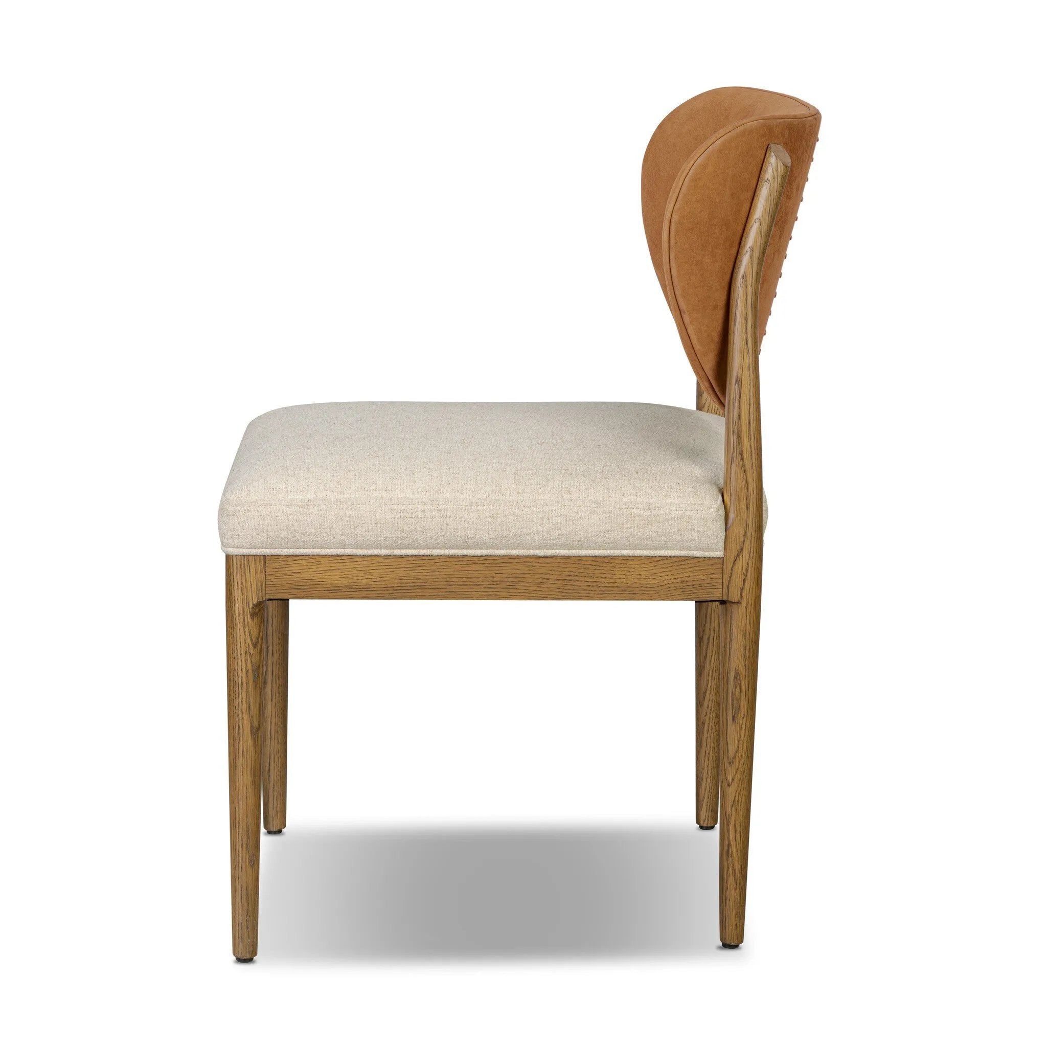 Midcentury meets organic modernism in this mixed-material dining chair. A top-grain leather seat back pairs with a cushioned seat upholstered in performance fabric, with stitch detailing along the seat back. All framed by solid oak finished in a warm amber. Amethyst Home provides interior design, new home construction design consulting, vintage area rugs, and lighting in the Omaha metro area.