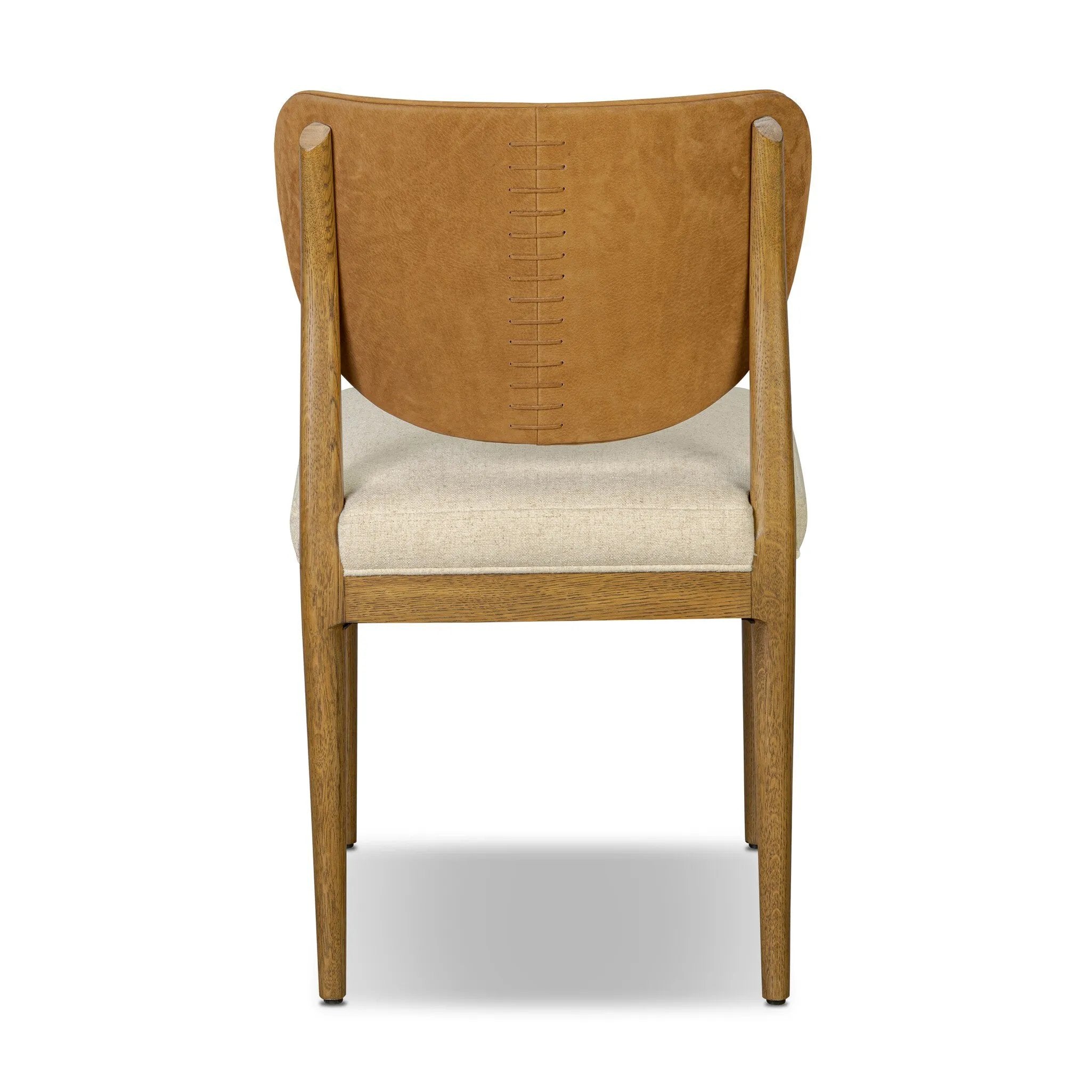 Midcentury meets organic modernism in this mixed-material dining chair. A top-grain leather seat back pairs with a cushioned seat upholstered in performance fabric, with stitch detailing along the seat back. All framed by solid oak finished in a warm amber. Amethyst Home provides interior design, new home construction design consulting, vintage area rugs, and lighting in the Salt Lake City metro area.