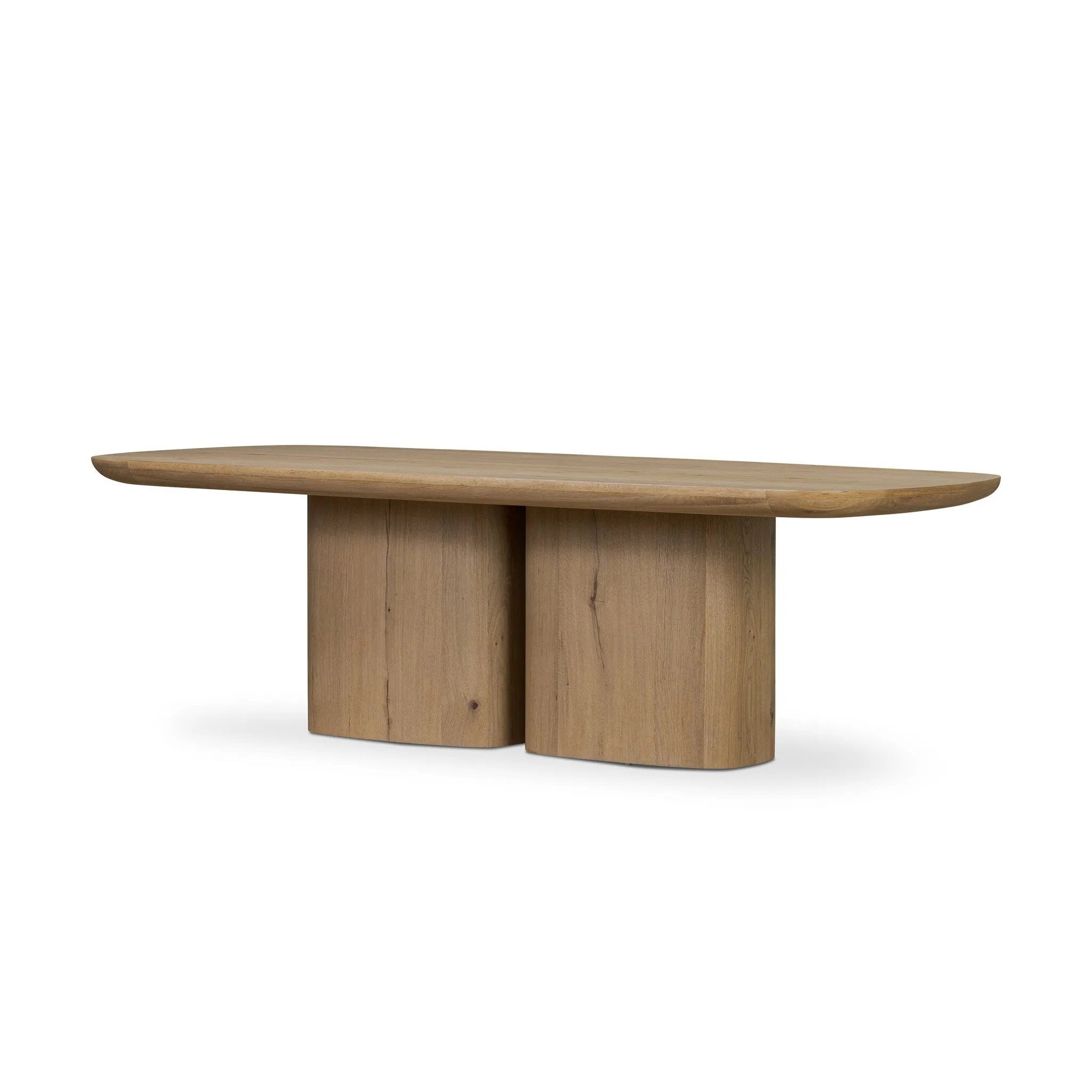 A stately dining style inspired by soft Brutalism. Crafted from aged smoked oak, a pair of matching pedestal bases features a delicate break between them, bringing a touch of lightness to such a substantial piece. A wide rectangular tabletop shapes arched sides that flow into rounded corners, finished off with bullnose edging Amethyst Home provides interior design, new home construction design consulting, vintage area rugs, and lighting in the Tampa metro area.
