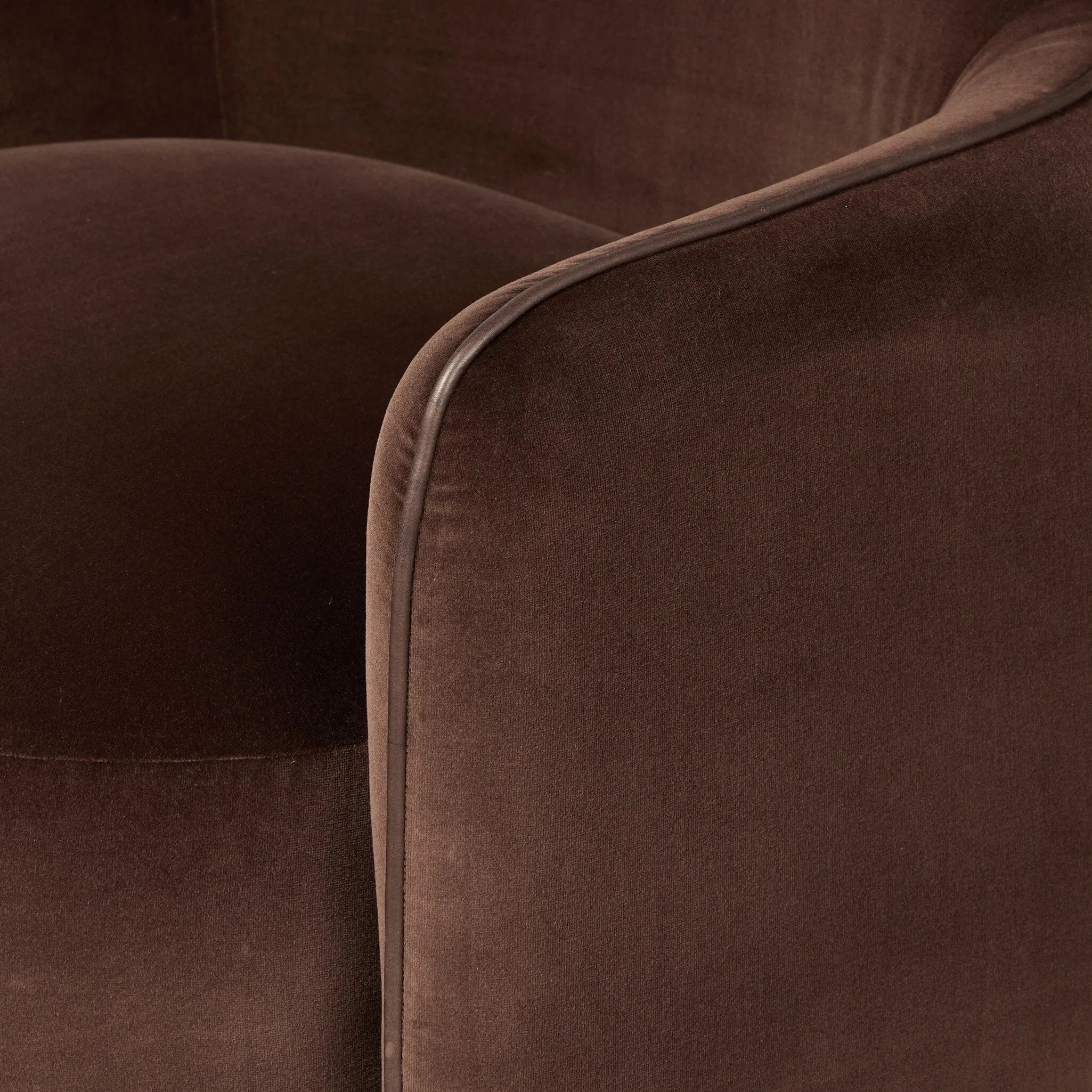 Compact and cozy, this high-back swivel chair with pillow-formed arms features contrast piping outlining its silhouette. Velvety performance fabric in a deep brown hue offers maximum comfort. The base is affixed to a 360-degree swivel for relaxed lounging. Amethyst Home provides interior design, new home construction design consulting, vintage area rugs, and lighting in the Salt Lake City metro area.