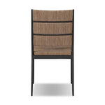 A steel dining chair frame is softened and paired with natural woven fibers. Thin, tapered legs and a tall channeled back cre