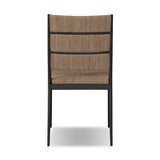 A steel dining chair frame is softened and paired with natural woven fibers. Thin, tapered legs and a tall channeled back cre