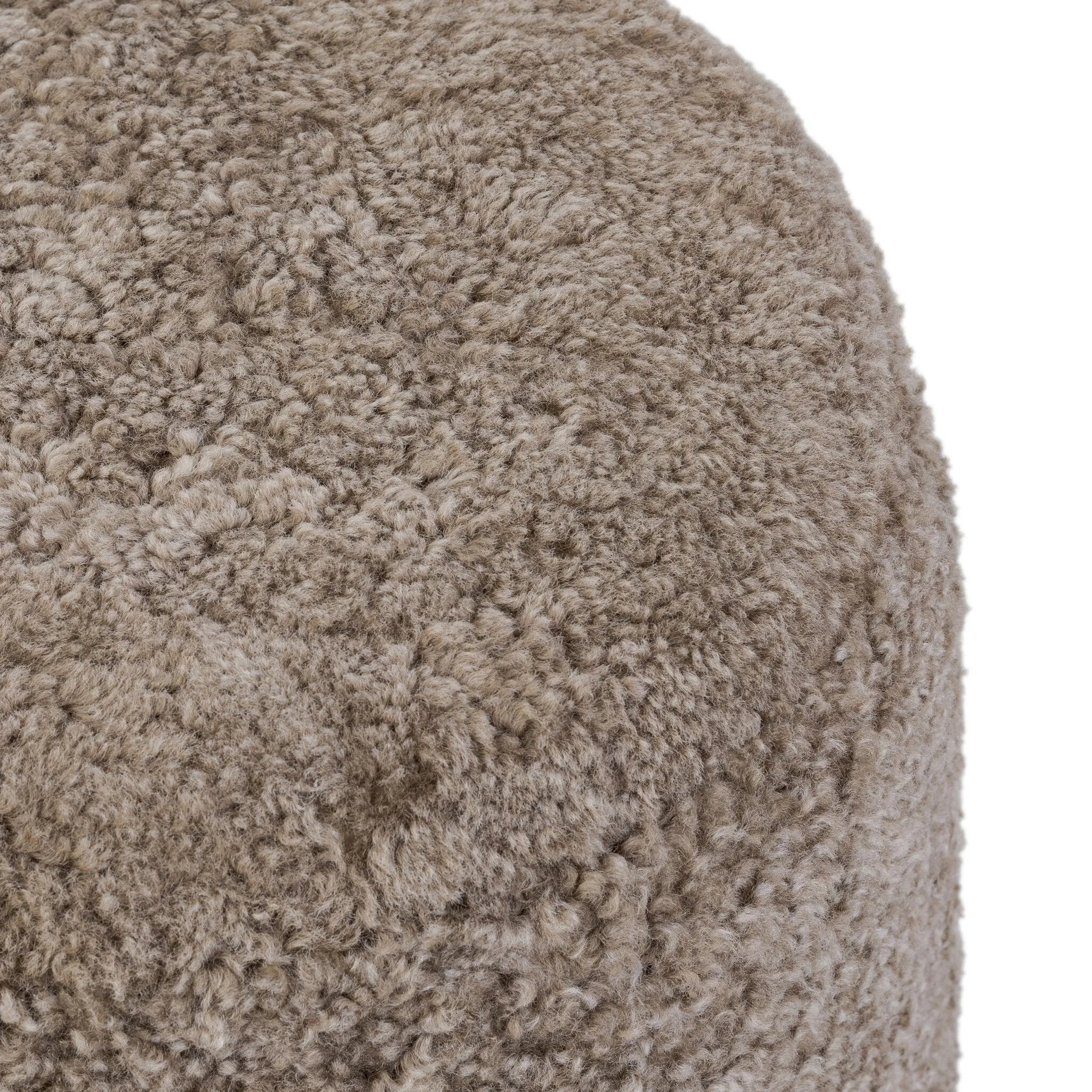 For an extra seat or propped feet, this welcoming ottoman features a subtly tapered shape and a rounded base with bun feet beneath. Crafted from solid oak and upholstered with taupe shearling for extra texture Amethyst Home provides interior design, new home construction design consulting, vintage area rugs, and lighting in the Des Moines metro area.