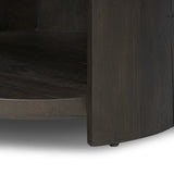 Rich contours bring character to the bedside. A round black-finished oak table has a spacious cubby and a single drawer with metal glides and a bronzed pull Amethyst Home provides interior design, new home construction design consulting, vintage area rugs, and lighting in the Seattle metro area.